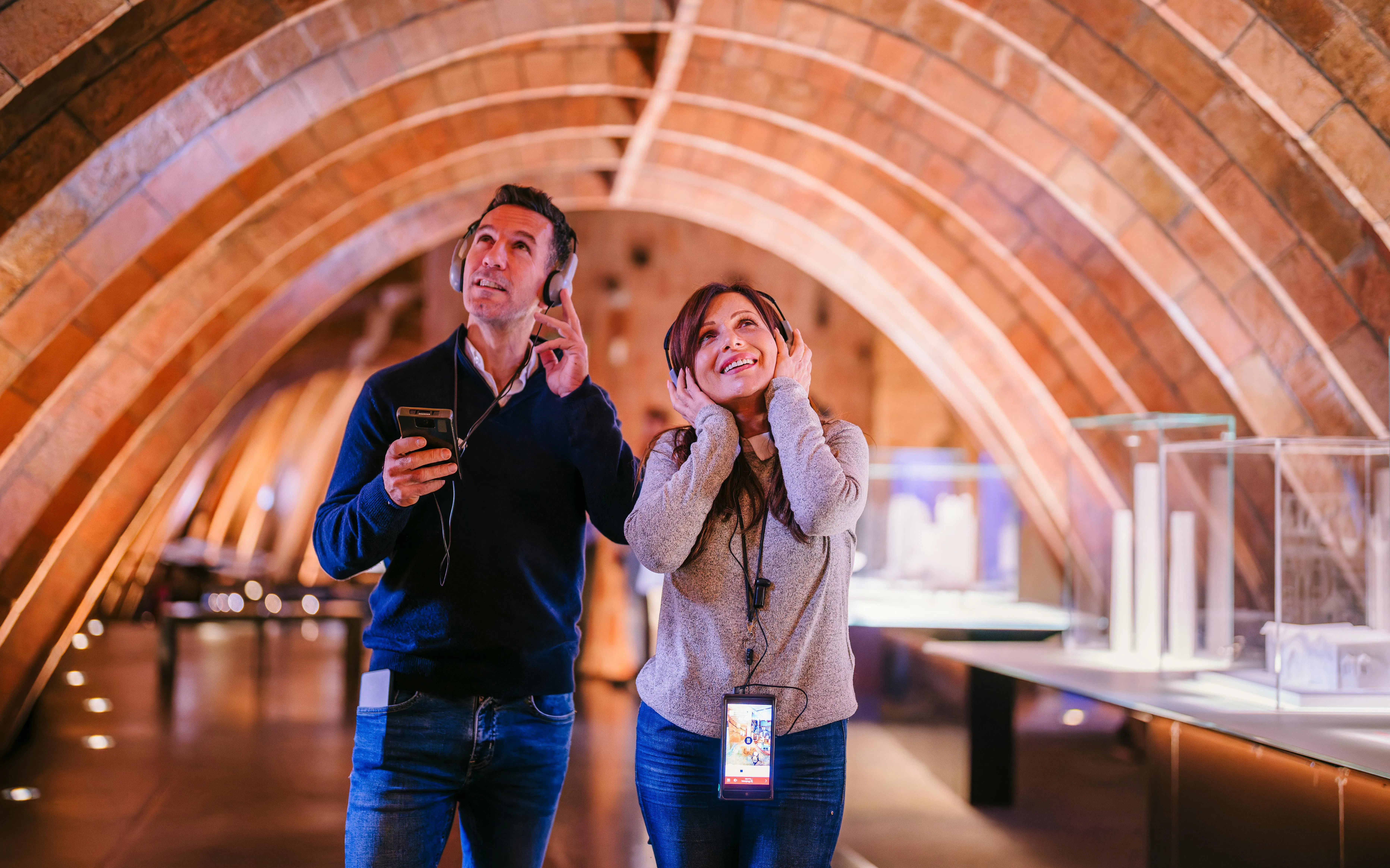 Visitors enjoying an audio tour at La Pedrera - Casa Milà during sunset.