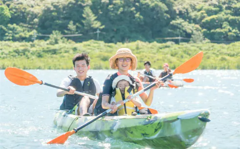 Family kayaking through mangroves on Iriomote SUP tour, Okinawa.