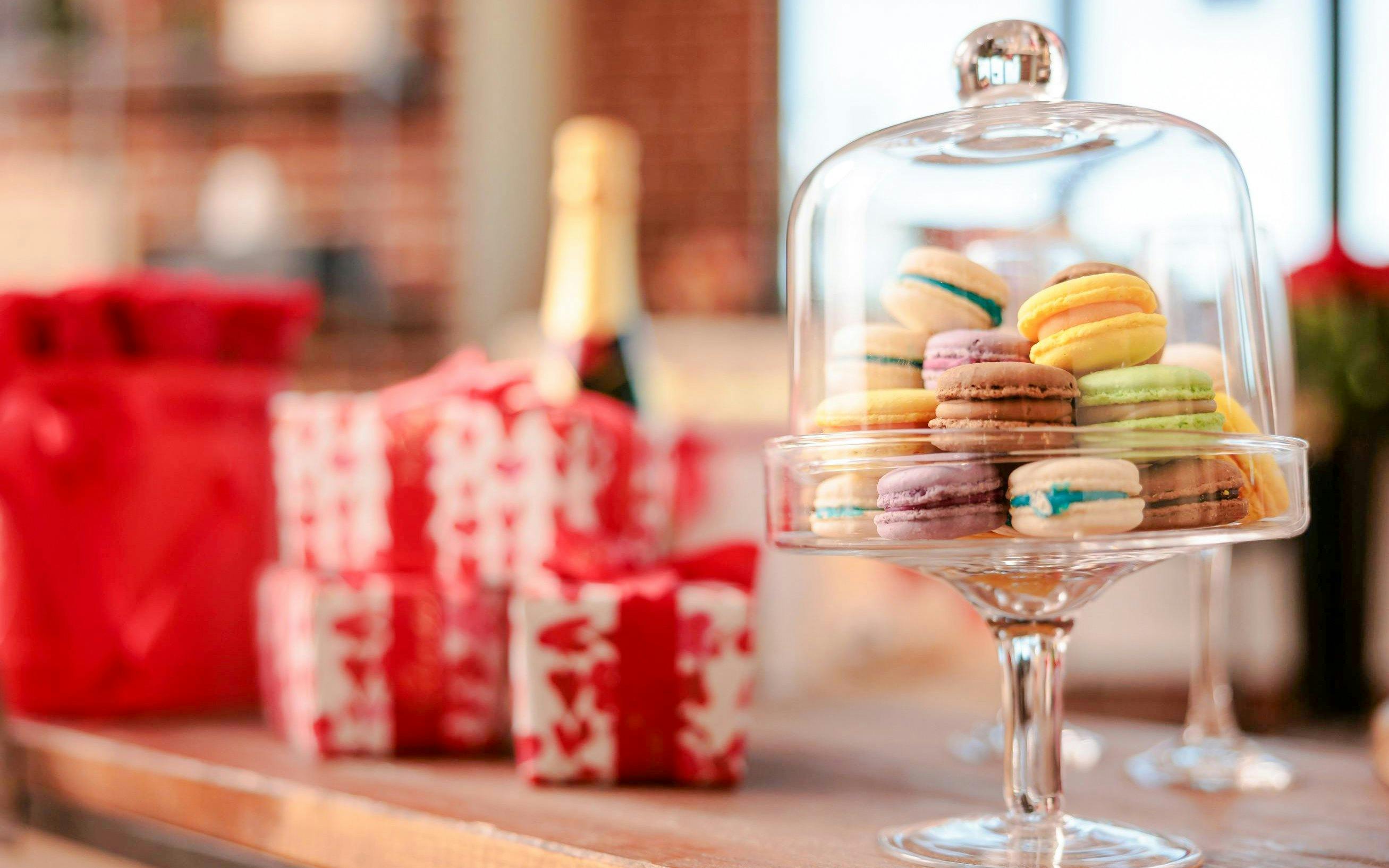 Macarons under glass dome with gift boxes, Paris tea time experience.