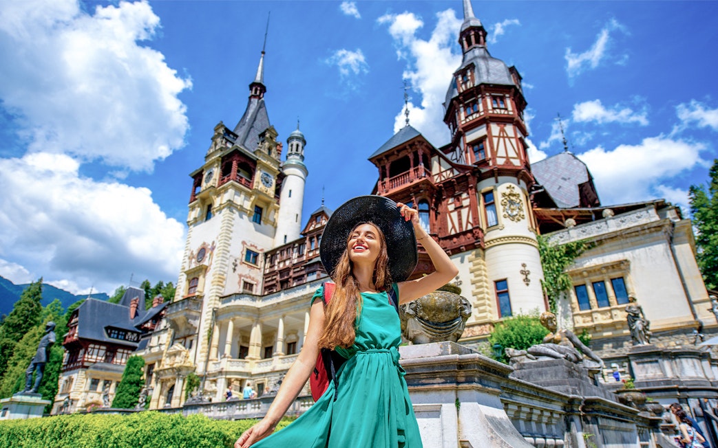 Tourist enjoying a sunny day at Peles Castle, Romania.