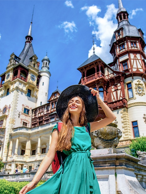 Tourist enjoying a sunny day at Peles Castle, Romania.