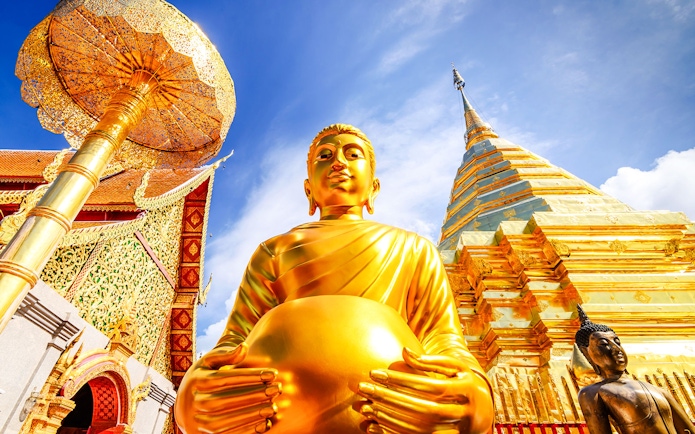 Golden Buddha statue and gleaming chedi at Wat Phra That Doi Suthep, Chiang Mai.