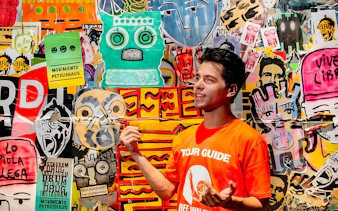 Tour guide explaining vibrant graffiti art in Buenos Aires.
