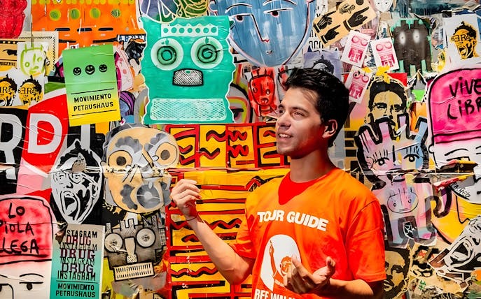 Tour guide explaining vibrant graffiti art in Buenos Aires.