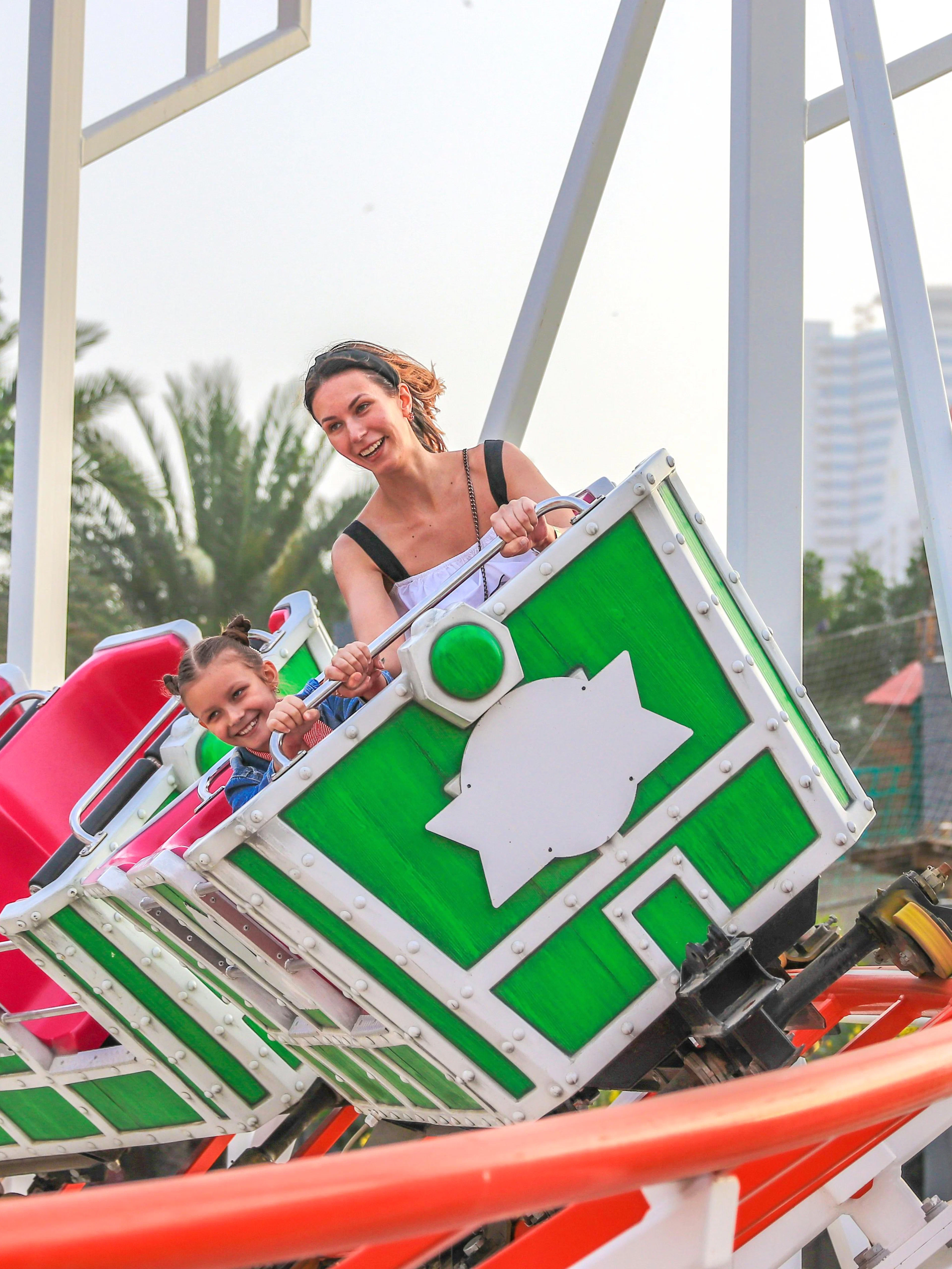 Roller coaster ride at Al Montazah Parks, Island of Legends, with smiling riders.