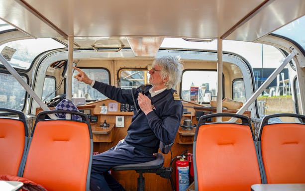 Boat captain narrating on Spaarne canal cruise from mill to mill.