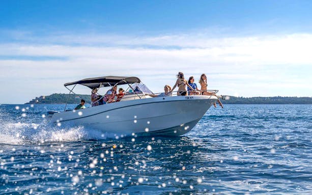 Guests on a speedboat tour admiring the Blue Cave and Bay of Kotor's scenic views.