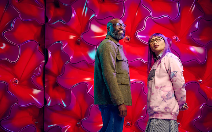 Visitors at Our Wondrous Planet exhibit, Melbourne Museum, with vibrant red backdrop.