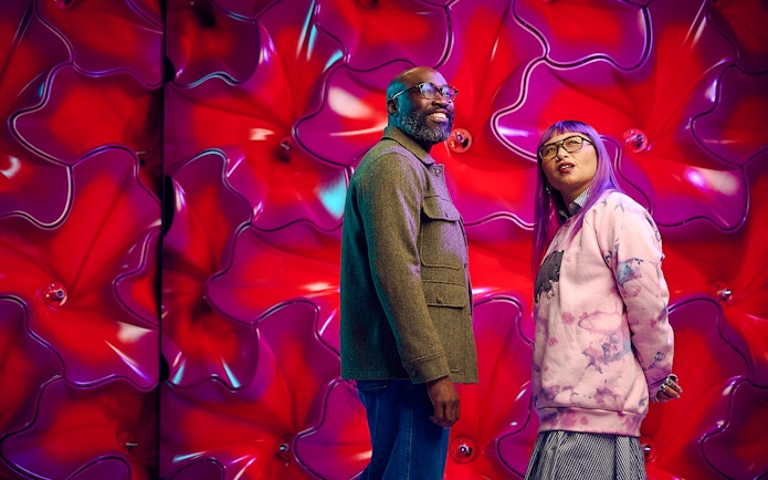 Visitors at Our Wondrous Planet exhibit, Melbourne Museum, with vibrant red backdrop.
