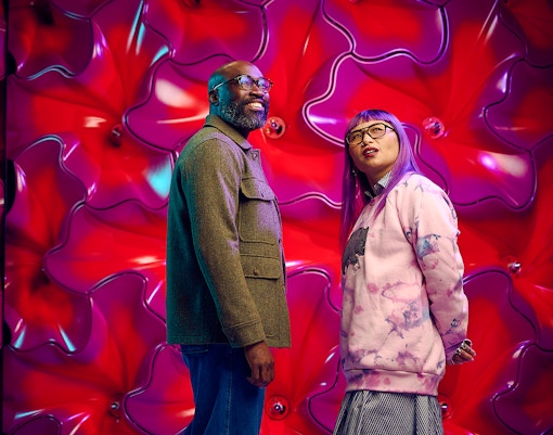 Visitors at Our Wondrous Planet exhibit, Melbourne Museum, with vibrant red backdrop.