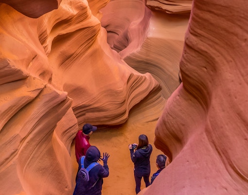 Tourists exploring the narrow sandstone formations of Antelope Canyon, Arizona.