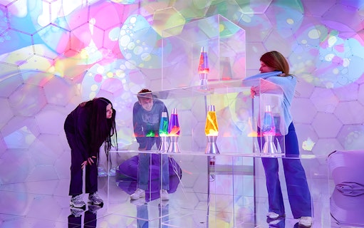 Visitors exploring colorful lava lamps at Bubble Planet immersive experience.