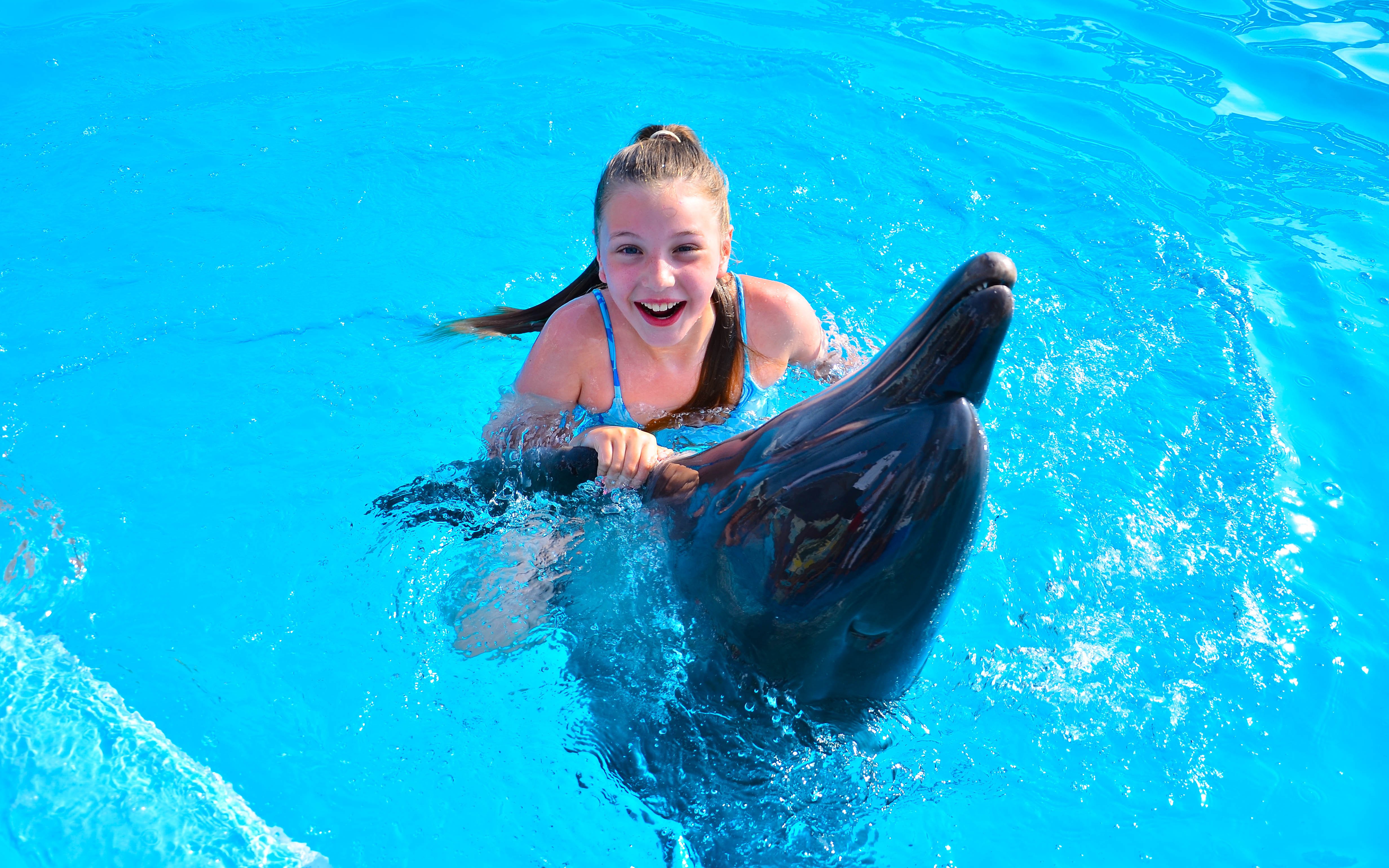 Girl swimming with dolphin at Dolphin World Egypt, Hurghada.