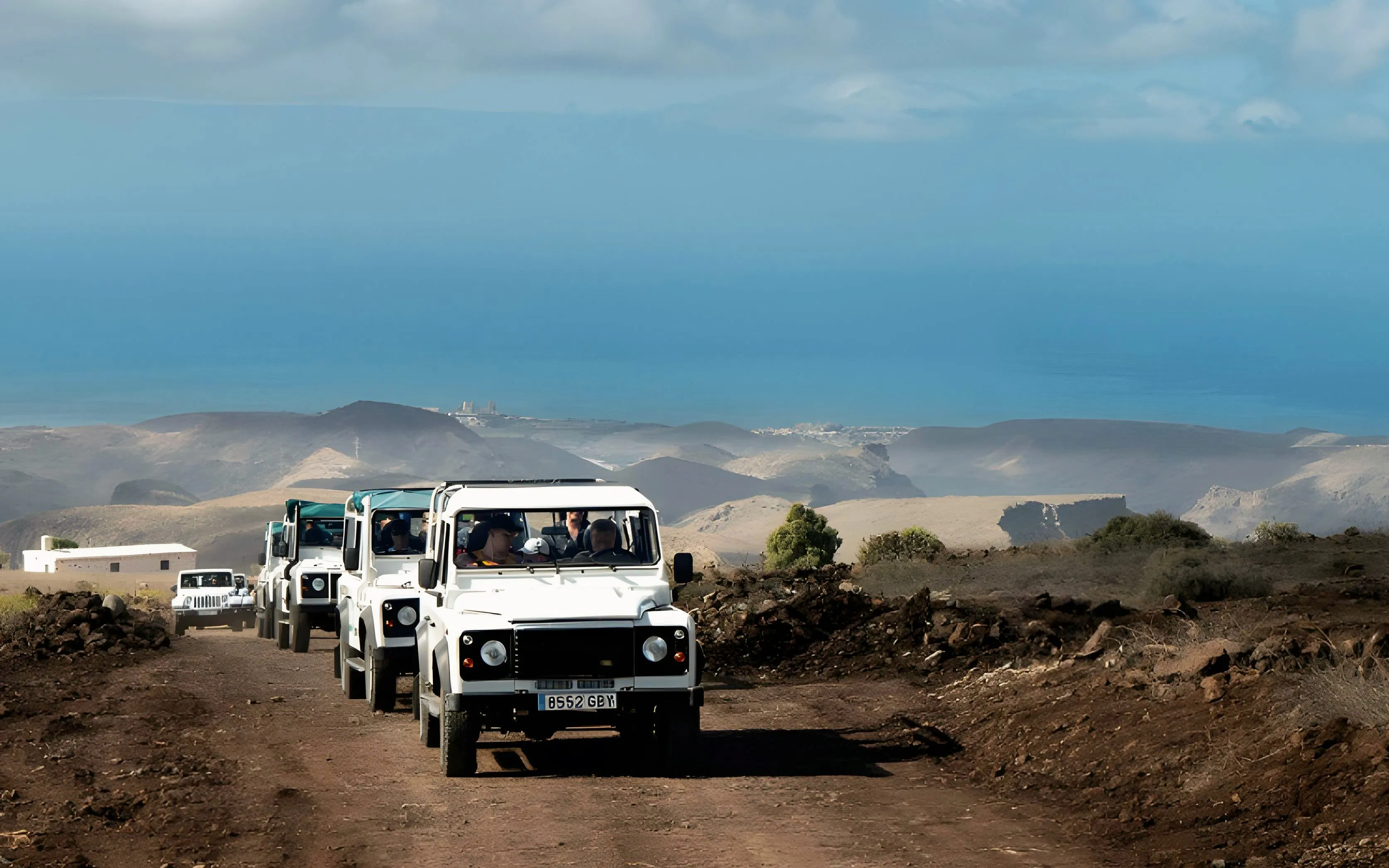 Jeep convoy on rugged terrain with ocean view in Gran Canaria.
