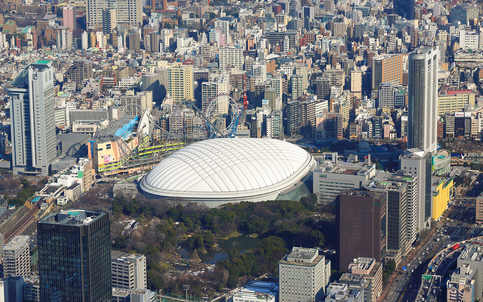 Aerial view of the dome shaped Tokyo Dome City surrounded by trees