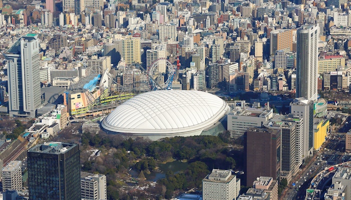 Aerial view of the dome shaped Tokyo Dome City surrounded by trees