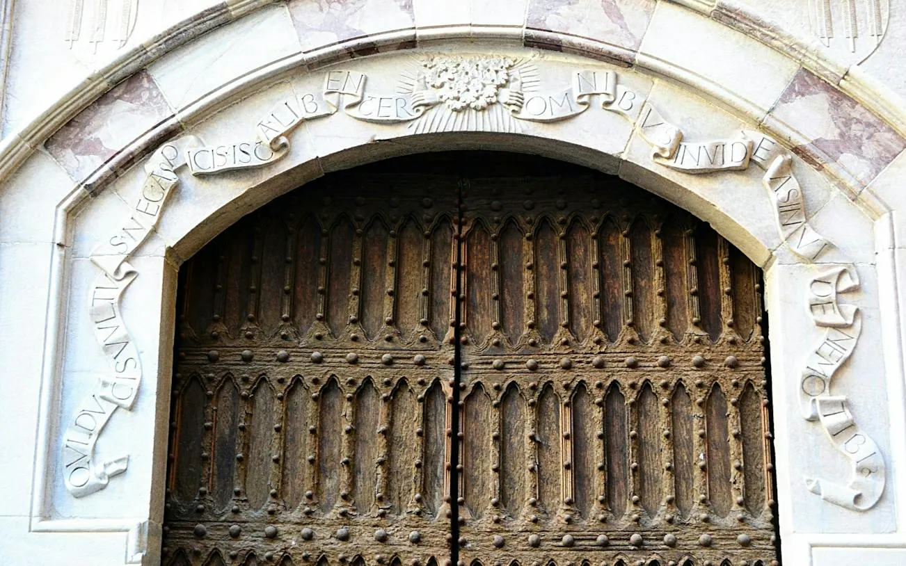 Ornate wooden door with Latin inscription in Naples, part of the Hidden History exploration game.