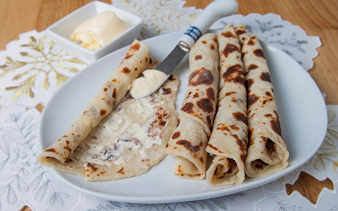 Norwegian lefse with butter on a plate, traditional snack for Aurora borealis tour.