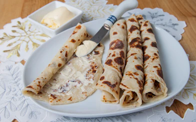 Norwegian lefse with butter on a plate, traditional snack for Aurora borealis tour.