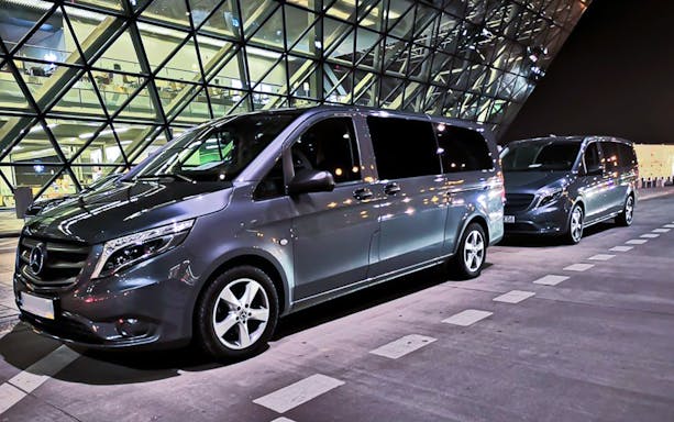 Minivans parked outside Krakow Balice Airport for transfer service.