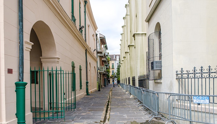 Narrow cobblestone alley in Pirate's Alley, French Quarter, New Orleans.