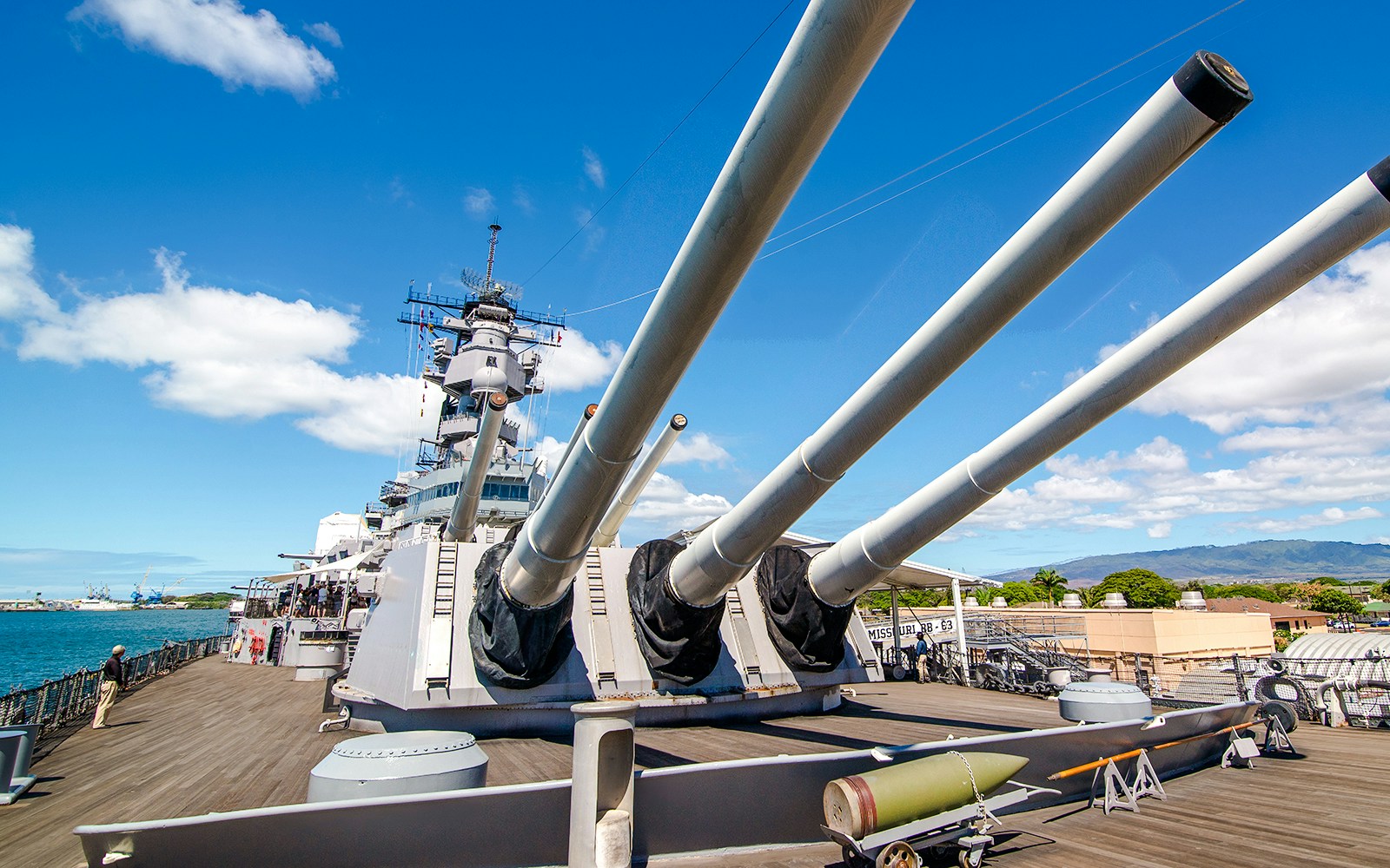 Missouri Battleship Memorial deck with large naval guns under a clear sky.