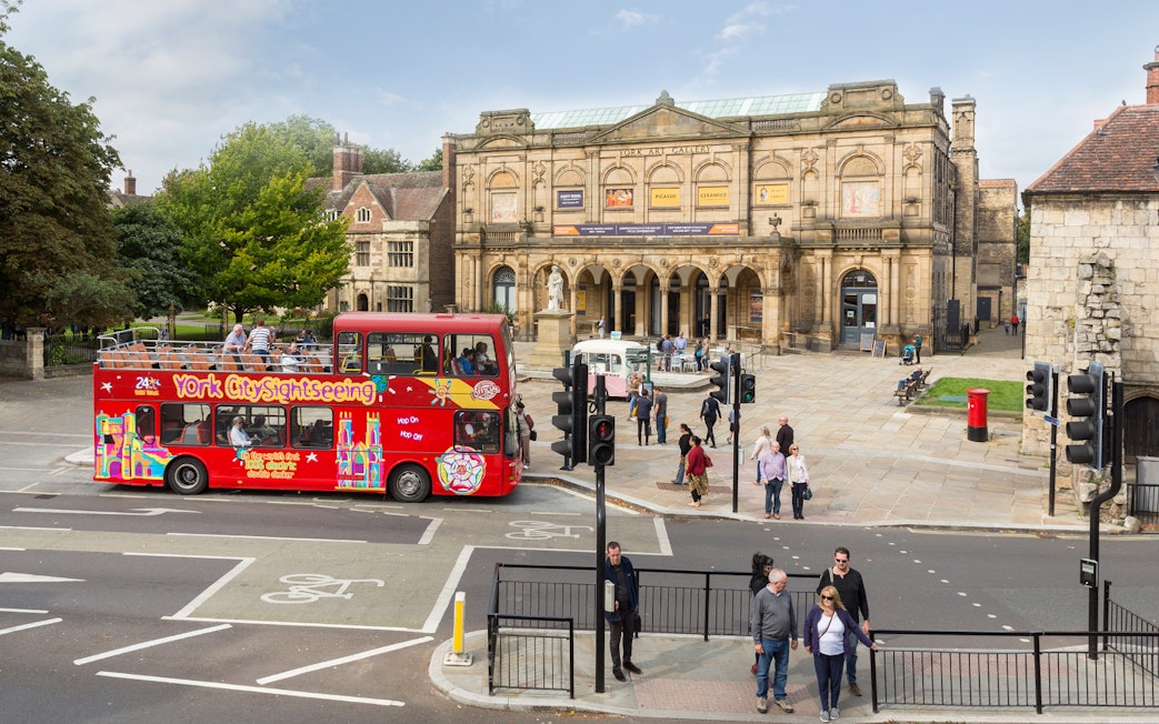 York sightseeing bus in front of York Art Gallery on a sunny day.