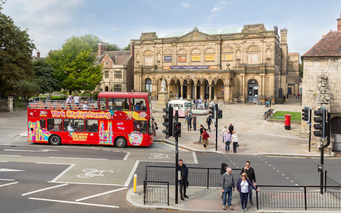 York sightseeing bus in front of York Art Gallery on a sunny day.