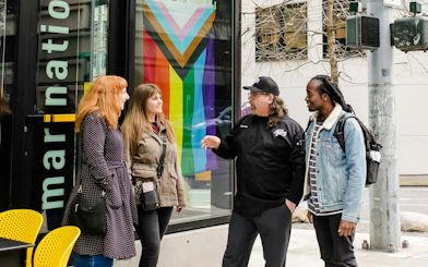 Group enjoying Seattle Happy Hour Tour outside a colorful cafe.