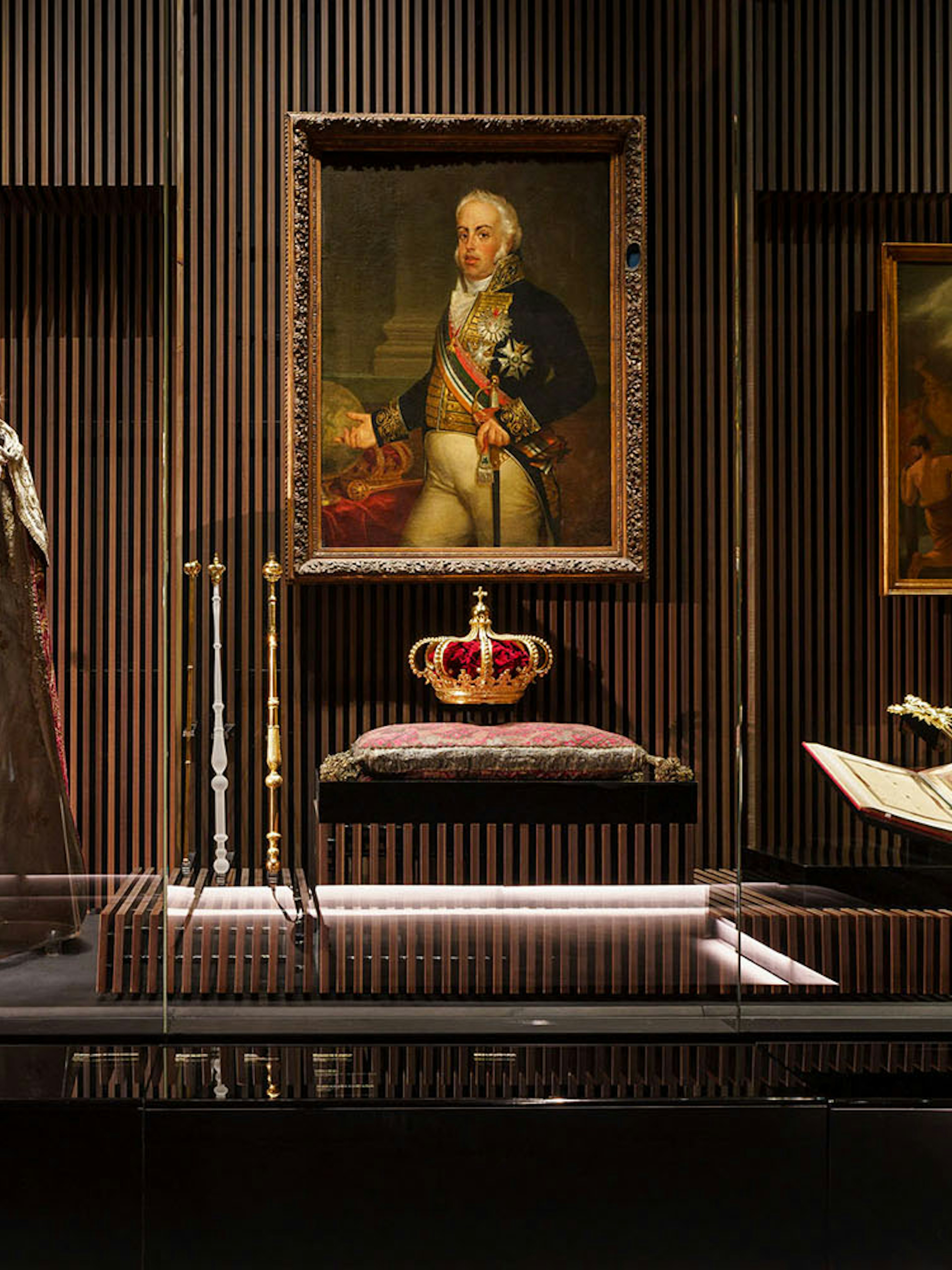 Royal Treasure Museum display with regal robe, crown, and historical paintings.