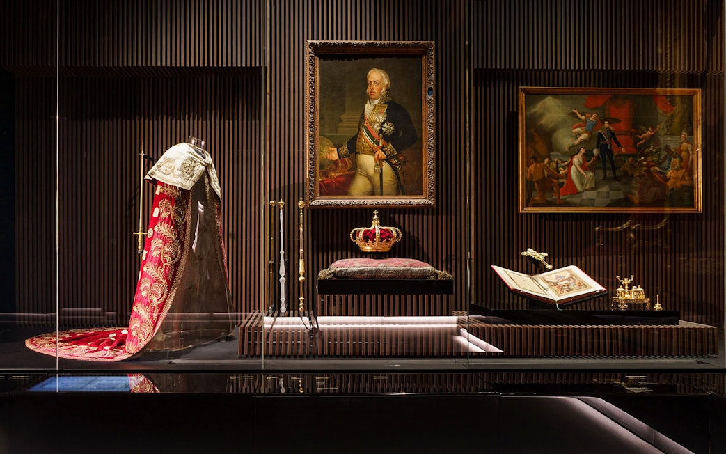 Royal Treasure Museum display with regal robe, crown, and historical paintings.