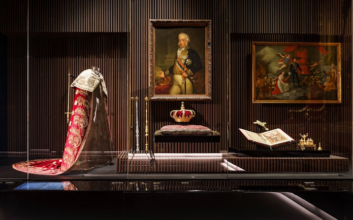 Royal Treasure Museum display with regal robe, crown, and historical paintings.