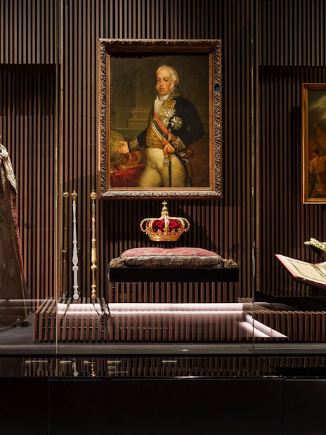 Royal Treasure Museum display with regal robe, crown, and historical paintings.