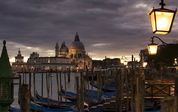 Venice Grand Canal at night with Santa Maria della Salute and gondolas.