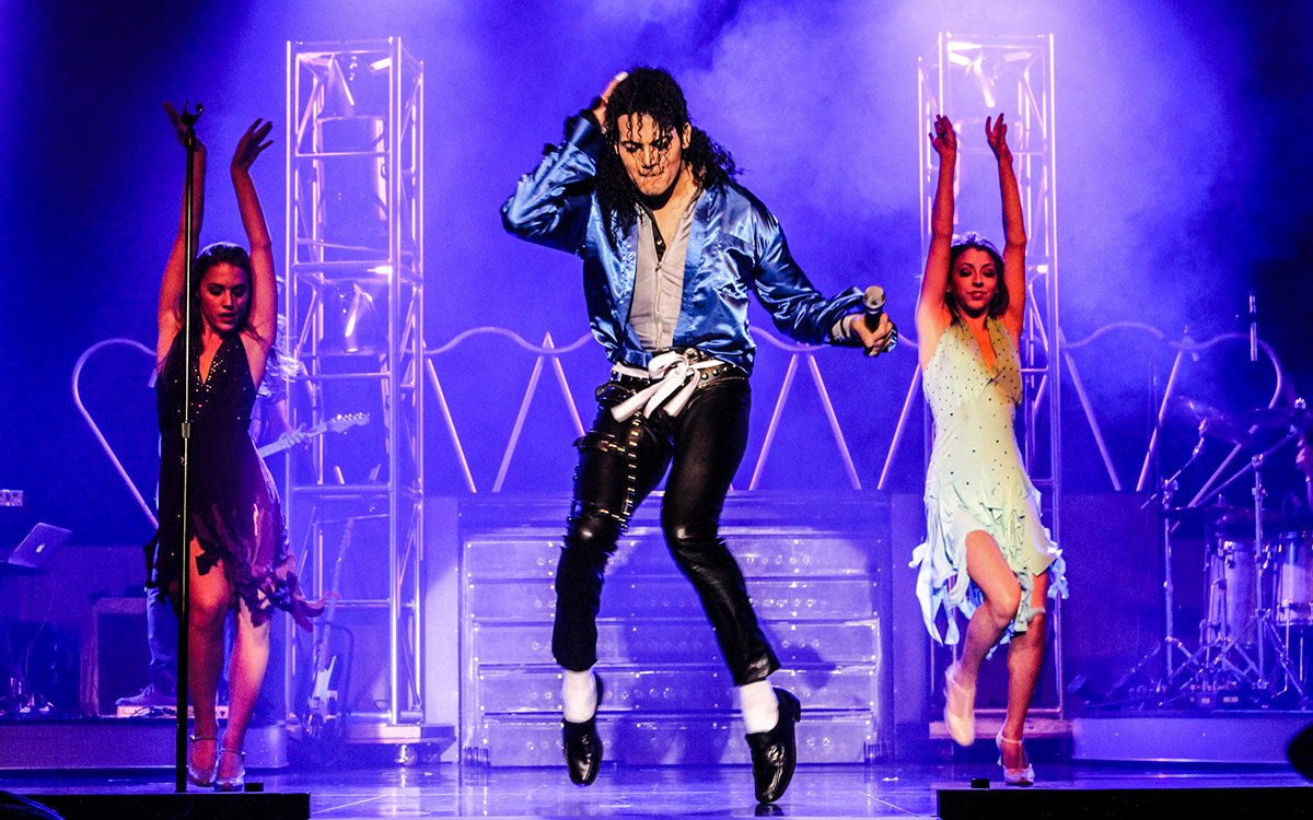 Performer in blue jacket dancing on stage during MJ Live show in Las Vegas.