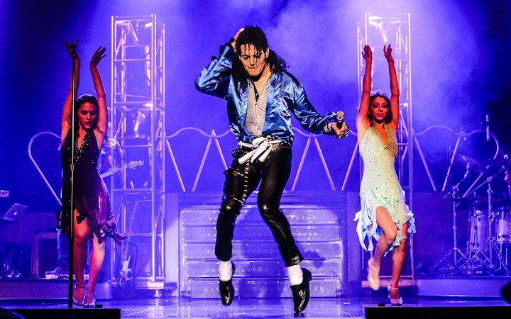 Performer in blue jacket dancing on stage during MJ Live show in Las Vegas.