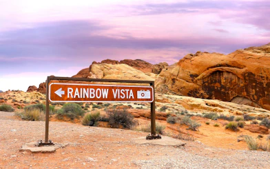 Rainbow Vista sign in Valley of Fire State Park, Nevada, with red rock formations.