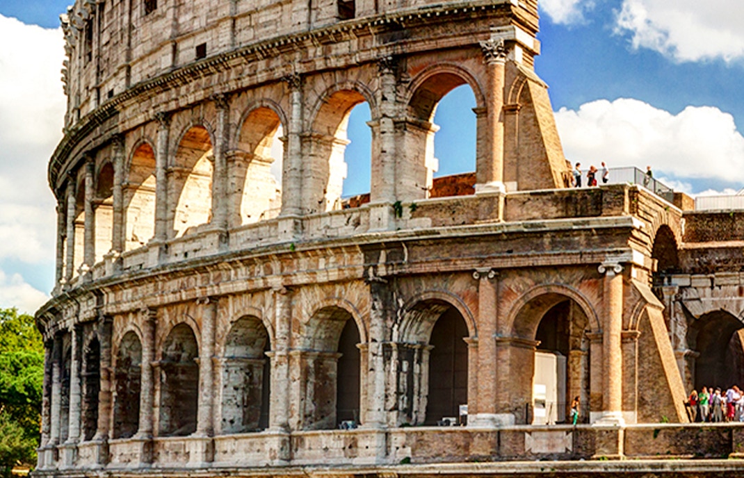 Colosseum in Rome with tourists exploring the ancient amphitheater.