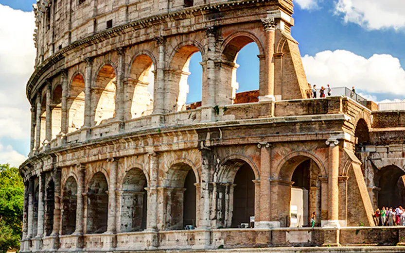 Colosseum in Rome with tourists exploring the ancient amphitheater.
