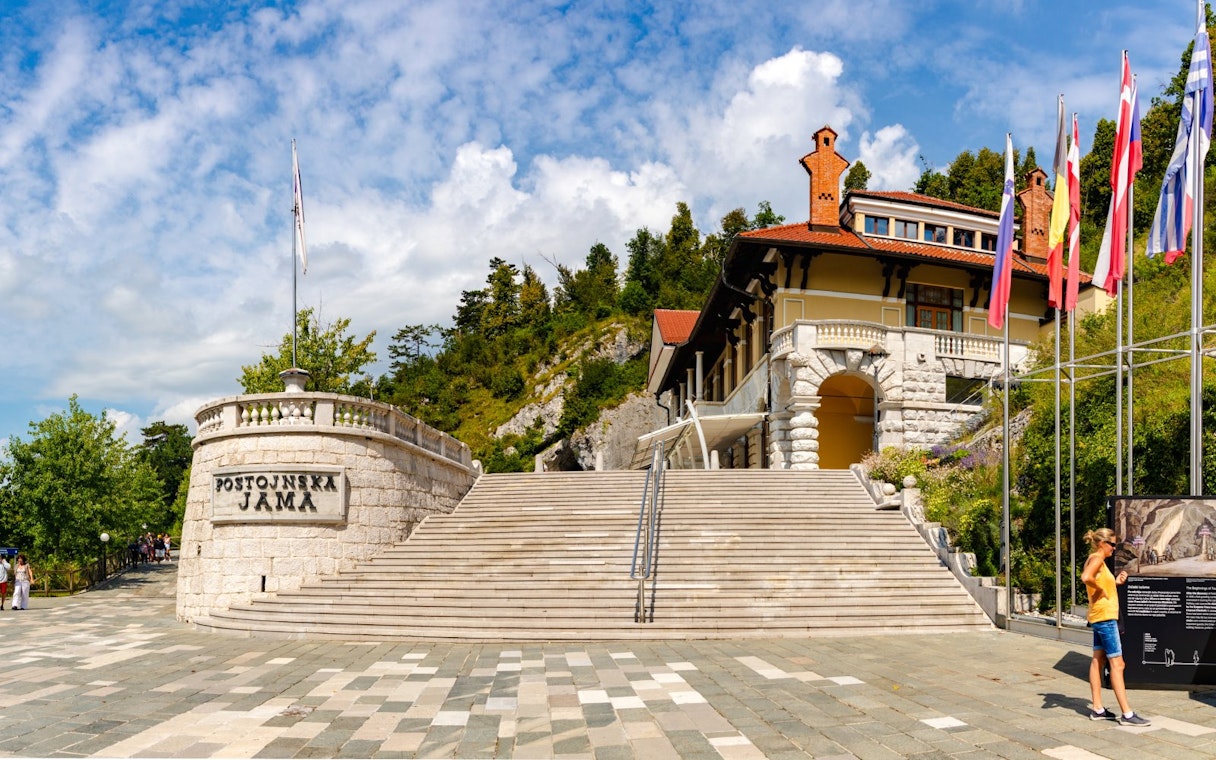 Postojna Cave entrance with stone steps and flags, Slovenia.