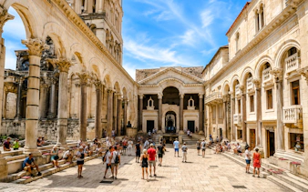 Peristyle Square in Diocletian's Palace, Split, with tourists exploring the historic architecture.