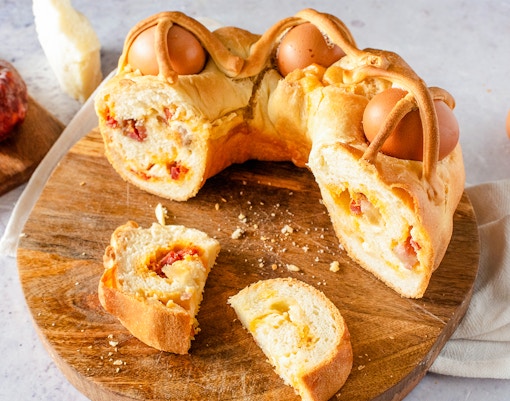Casatiello Milanese bread with salami and cheese on a wooden board in Milan, Italy.
