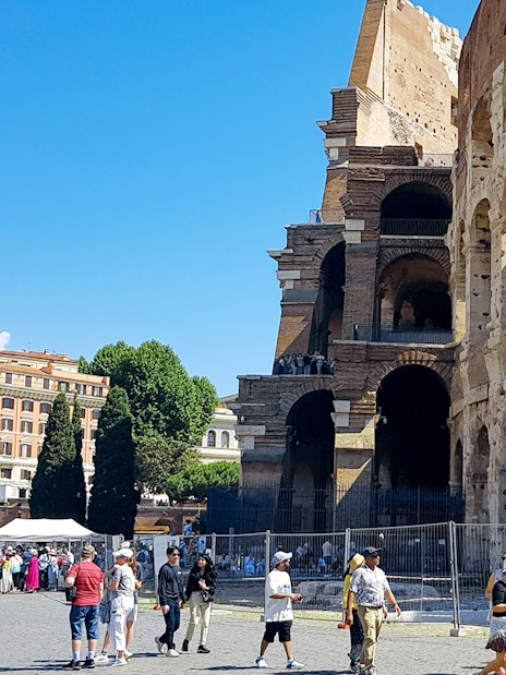 Tour group at the Colosseum with Palatine Hill and Roman Forum in Rome, Italy.
