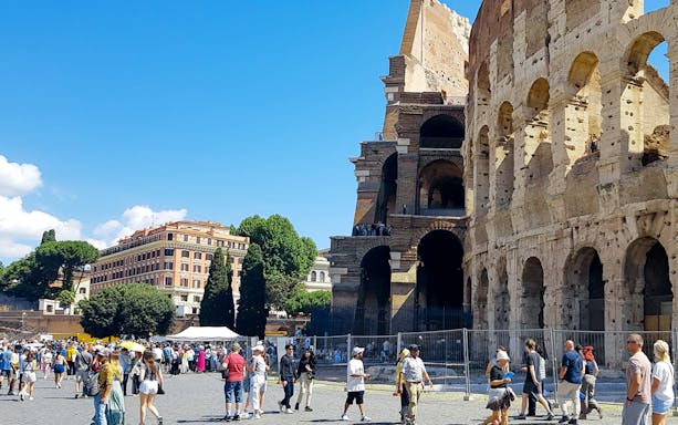 Tour group at the Colosseum with Palatine Hill and Roman Forum in Rome, Italy.