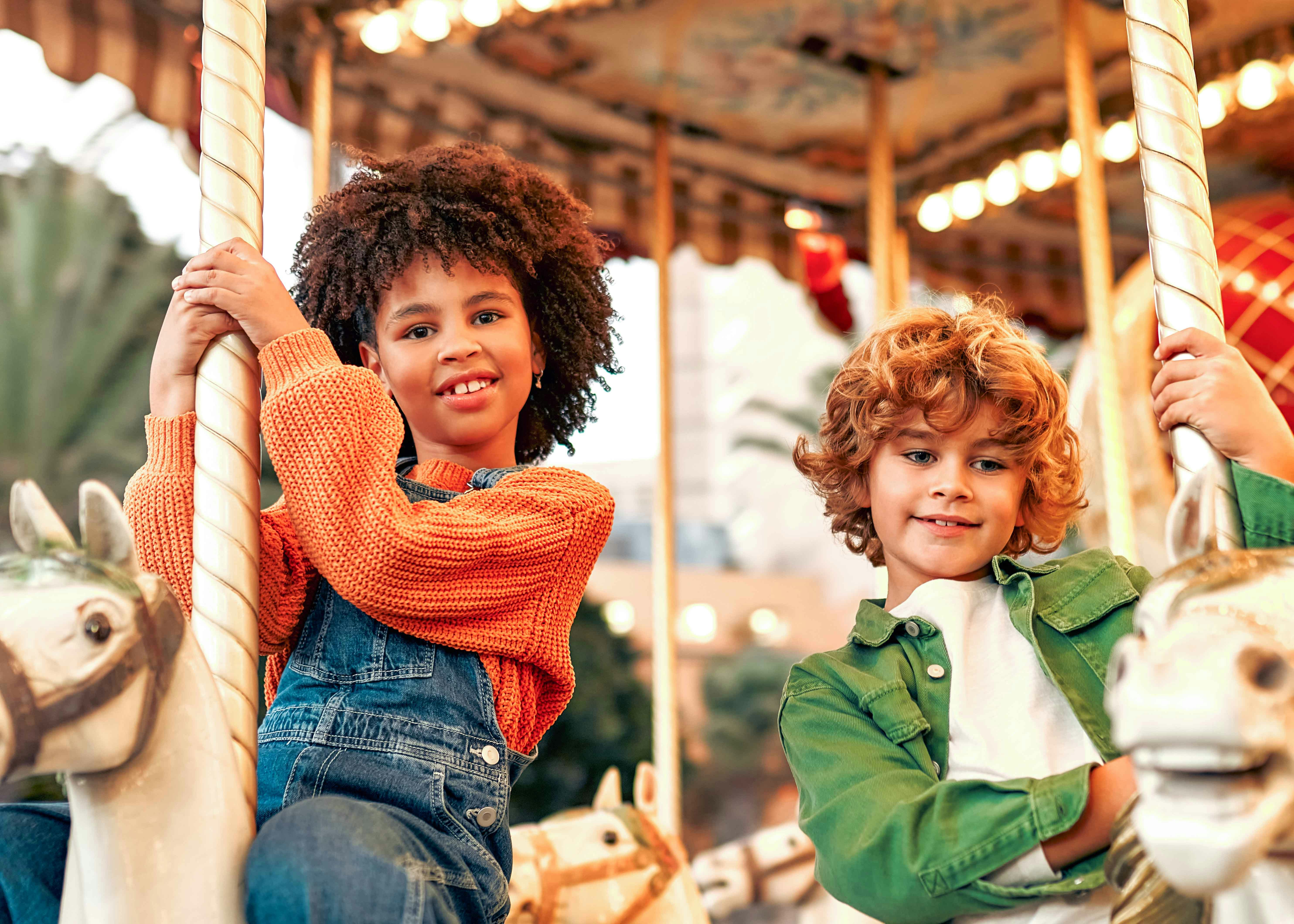 Children riding the Bug Carousel at Bronx Zoo, New York, featuring insect-themed seats.
