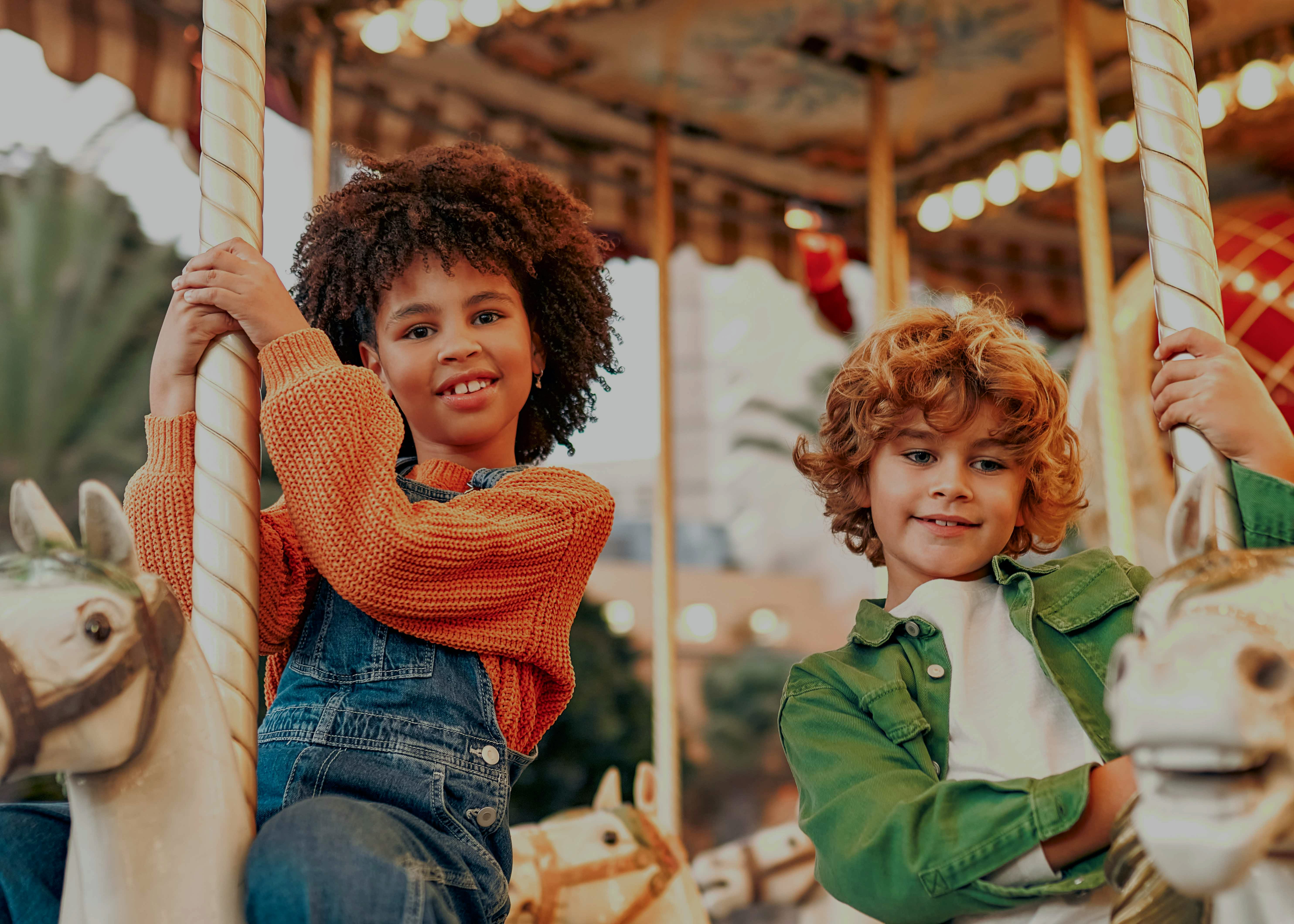 Children riding the Bug Carousel at Bronx Zoo, New York, featuring insect-themed seats.