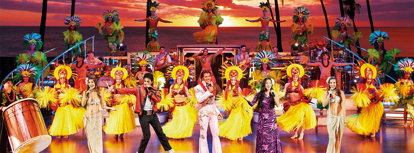 Performers on stage at Rock-A-Hula Show with dancers and musicians in Hawaiian attire.