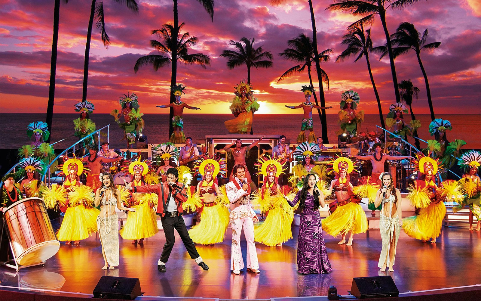 Performers on stage at Rock-A-Hula Show with dancers and musicians in Hawaiian attire.