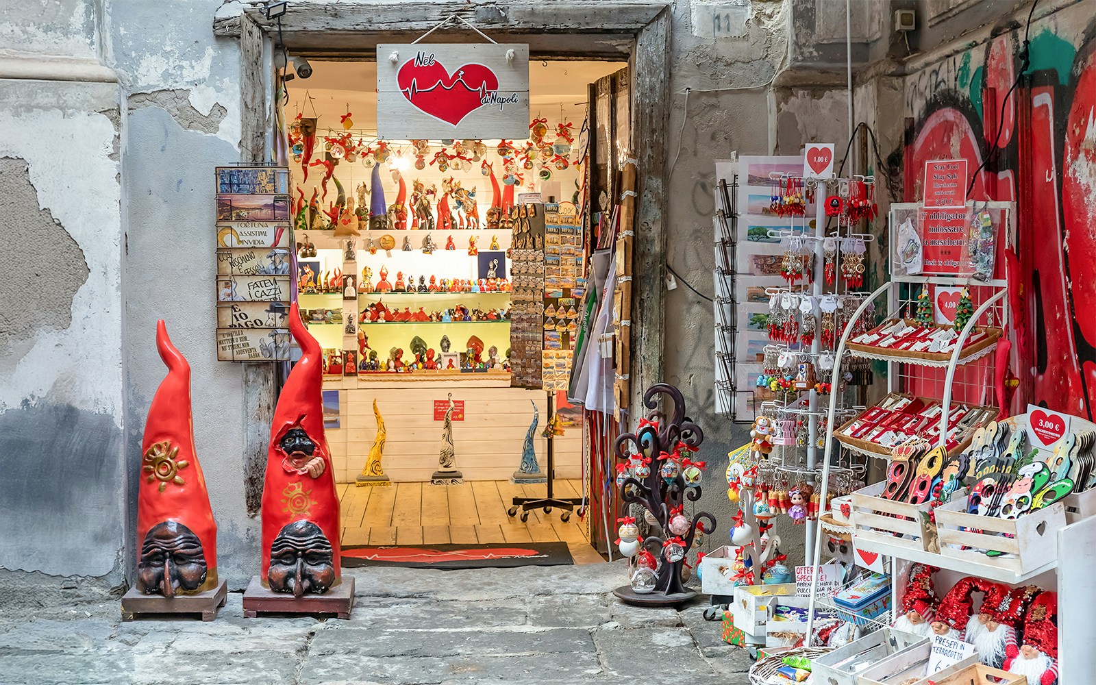 Neapolitan gift shop with Christmas gadgets on San Gregorio Armeno, Naples, featuring nativity scenes.