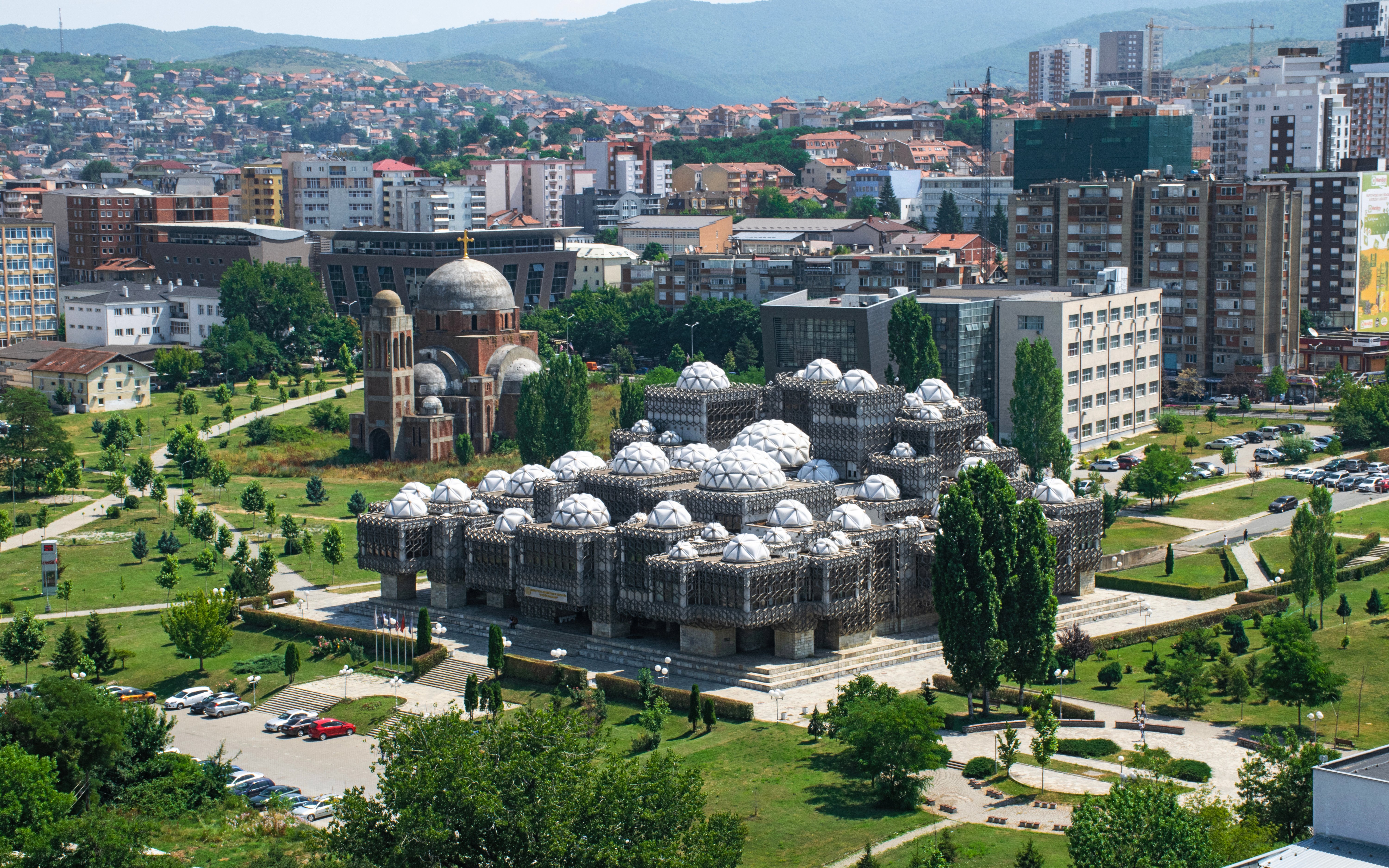 National Library of Kosovo with domed architecture in Pristina, surrounded by cityscape.